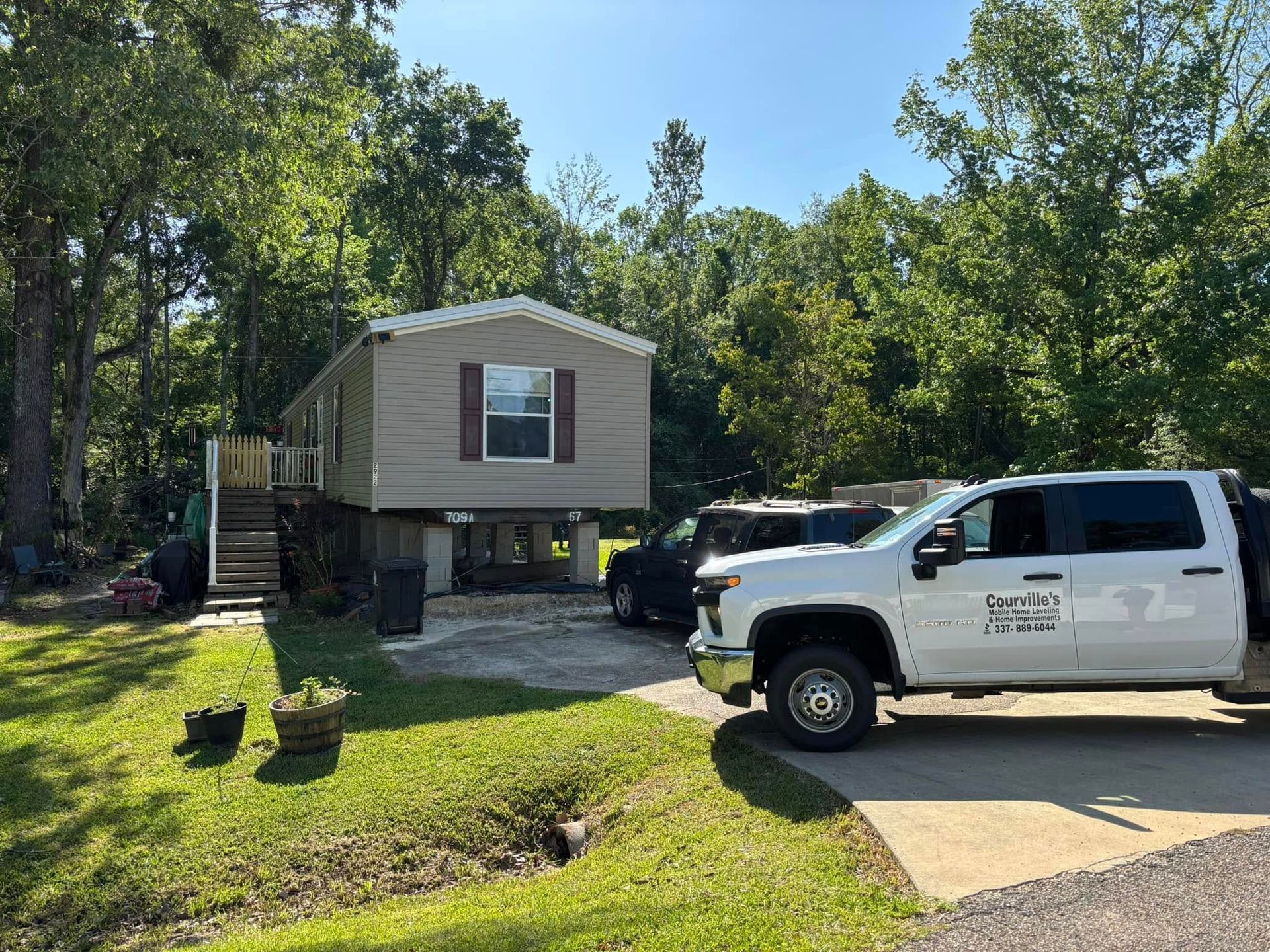 A white truck is parked in front of a mobile home.