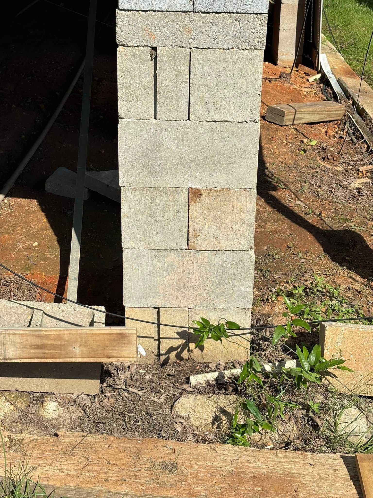 A brick wall is being built next to a wooden walkway.