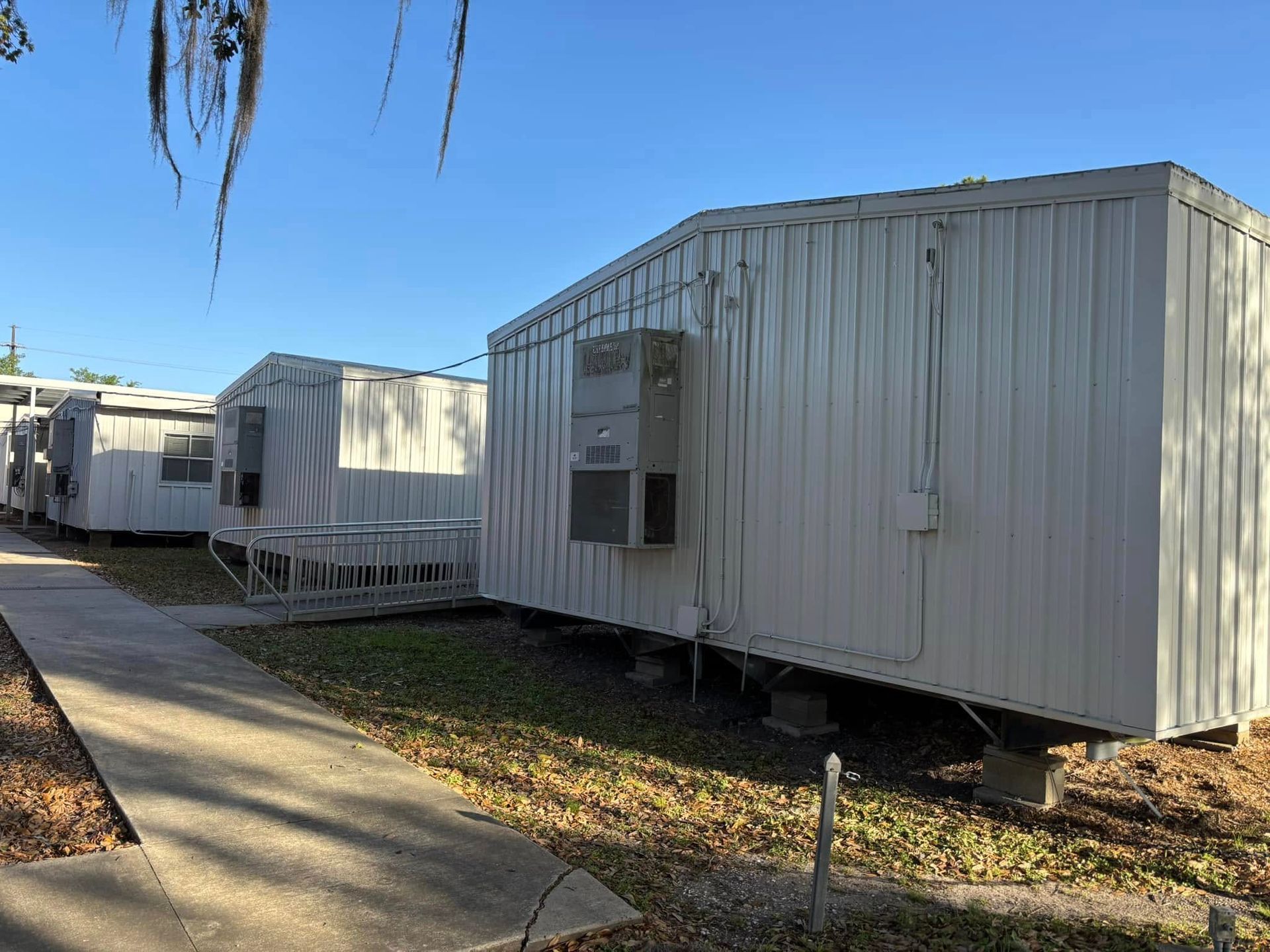 A row of mobile homes are parked next to each other on a sidewalk.