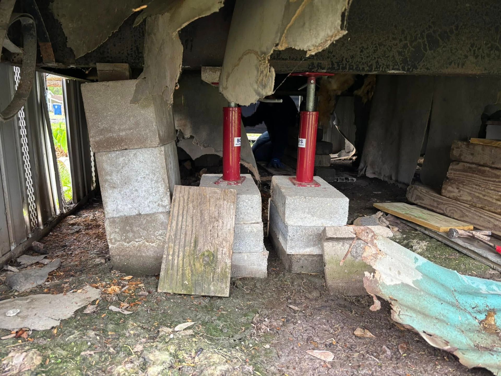 A red jack is sitting on top of a pile of concrete blocks.