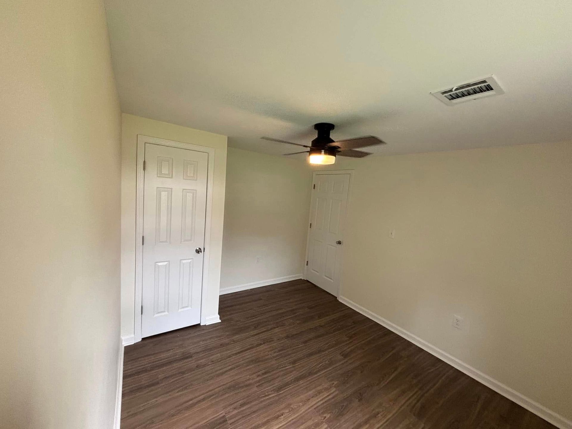 There is a ceiling fan in the corner of the room.