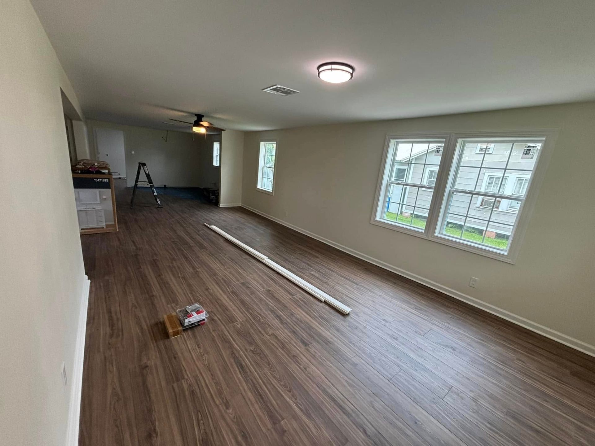 A large empty room with hardwood floors and white walls.