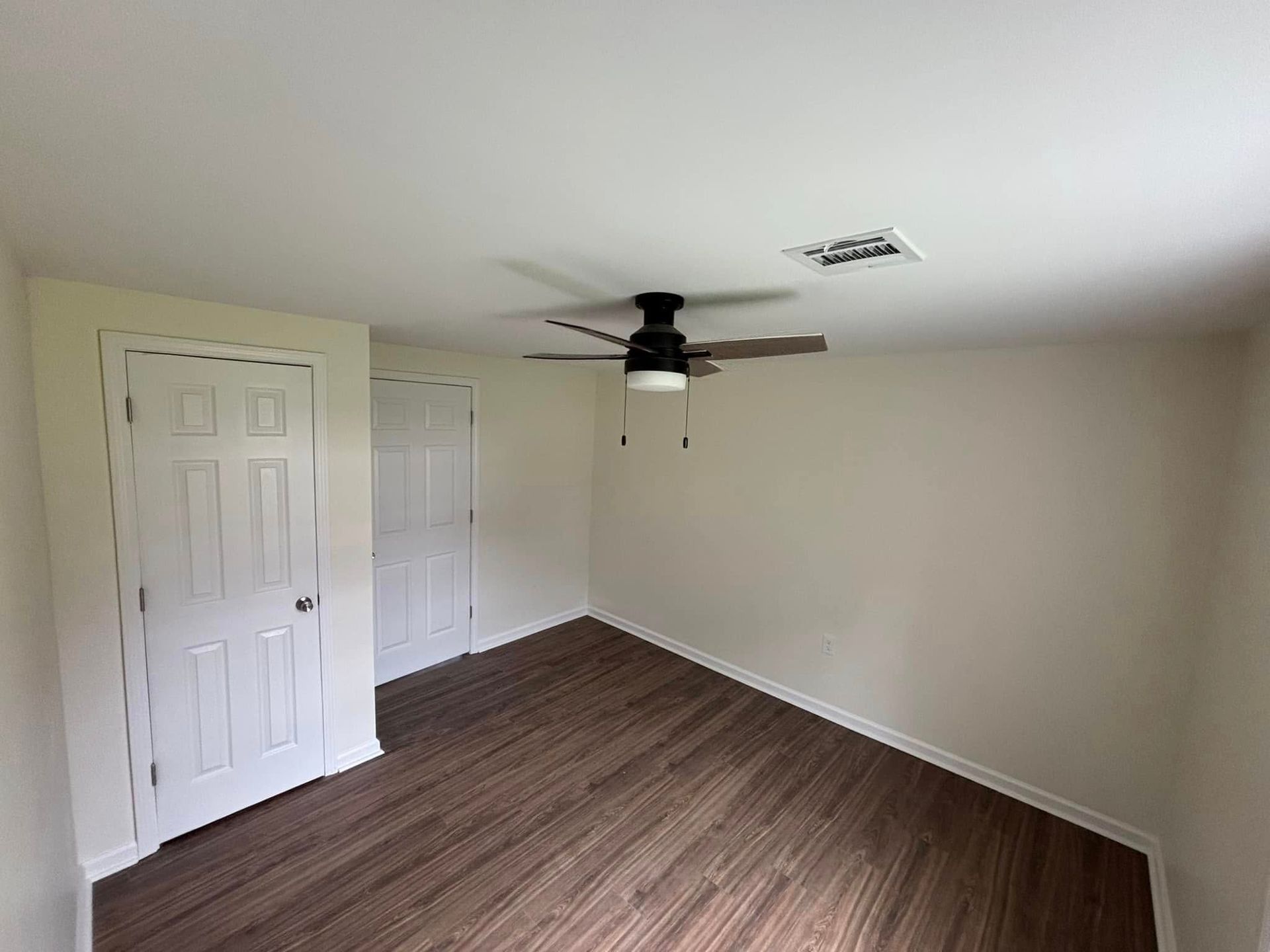 There is a ceiling fan in the corner of the room.