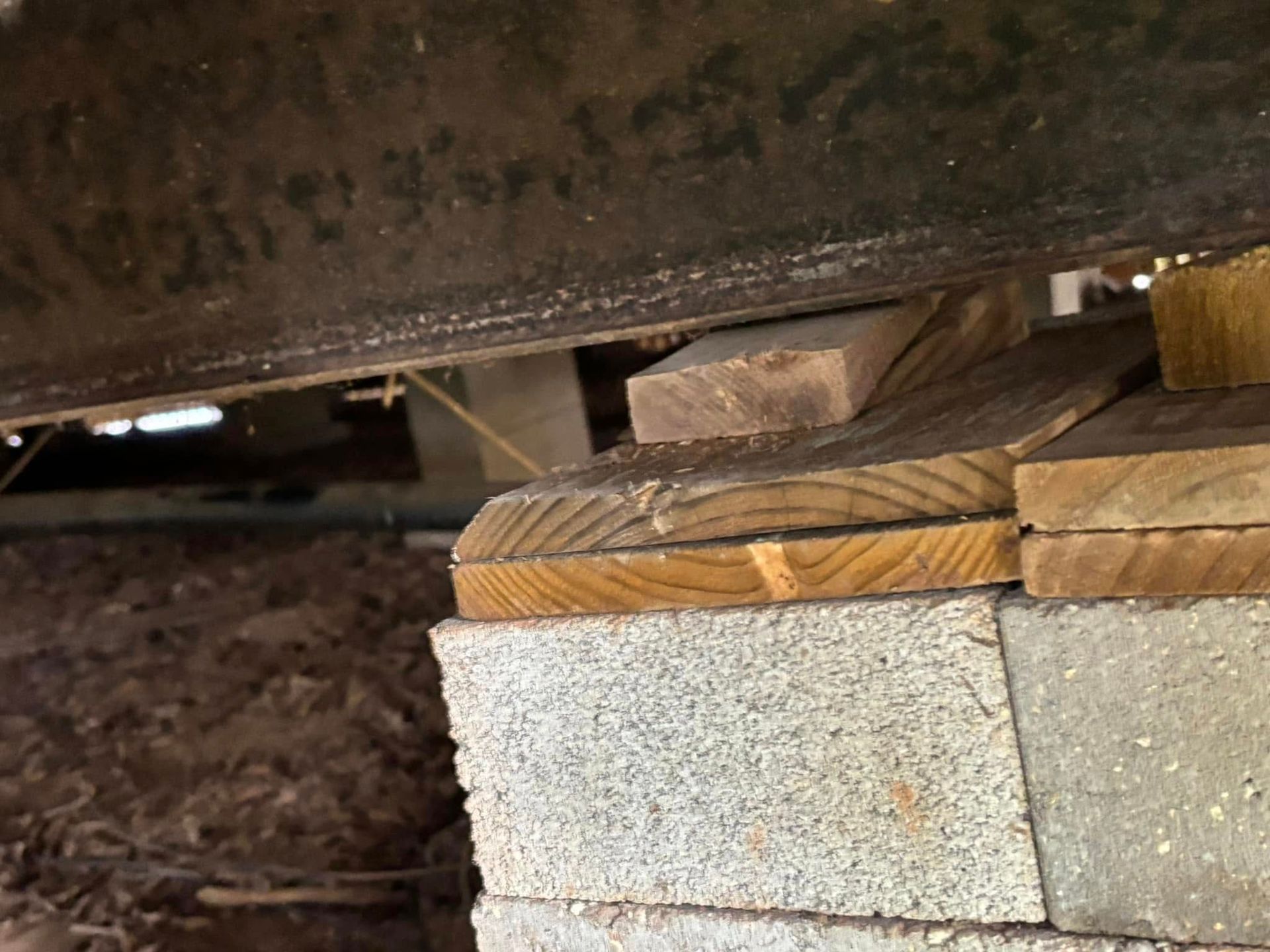 A piece of wood is sitting on top of a concrete block.
