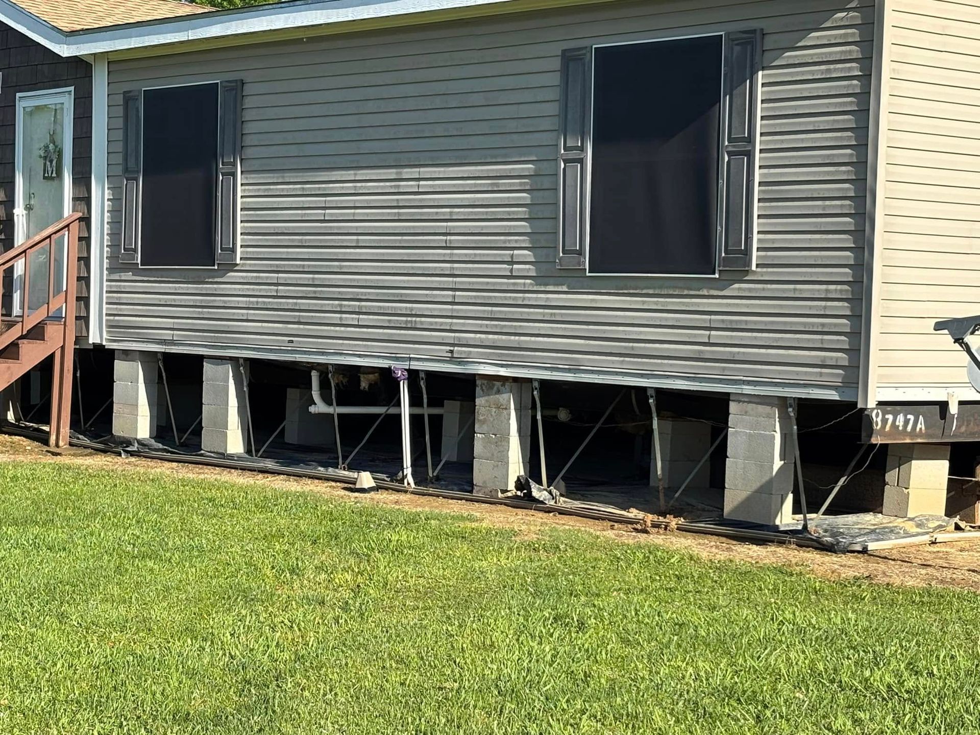 A mobile home is sitting on top of a lush green lawn.