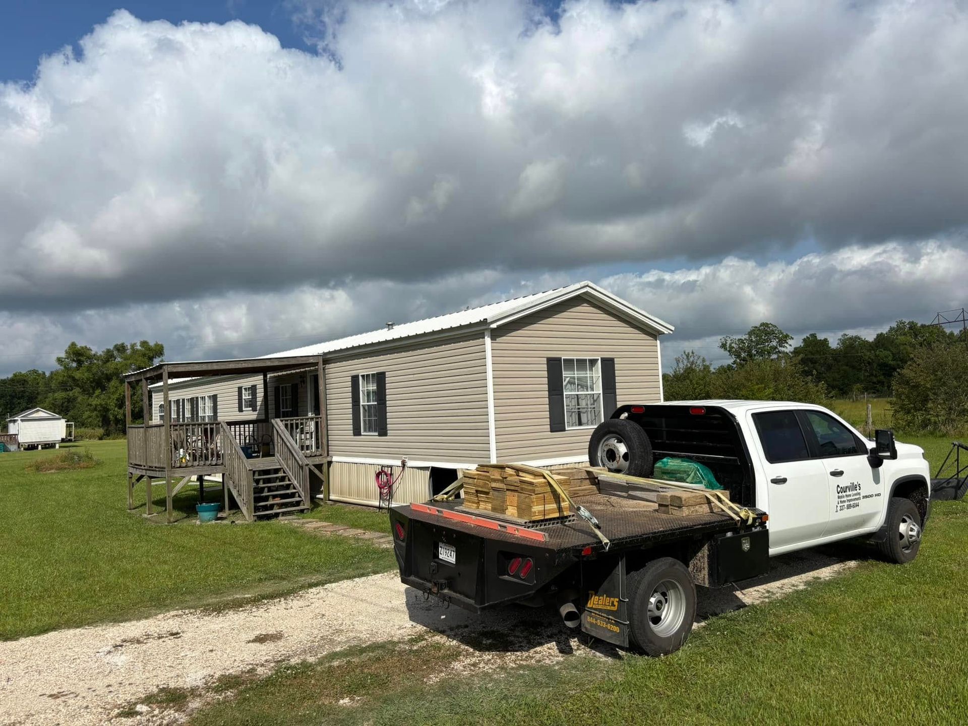 A white truck is parked in front of a mobile home.