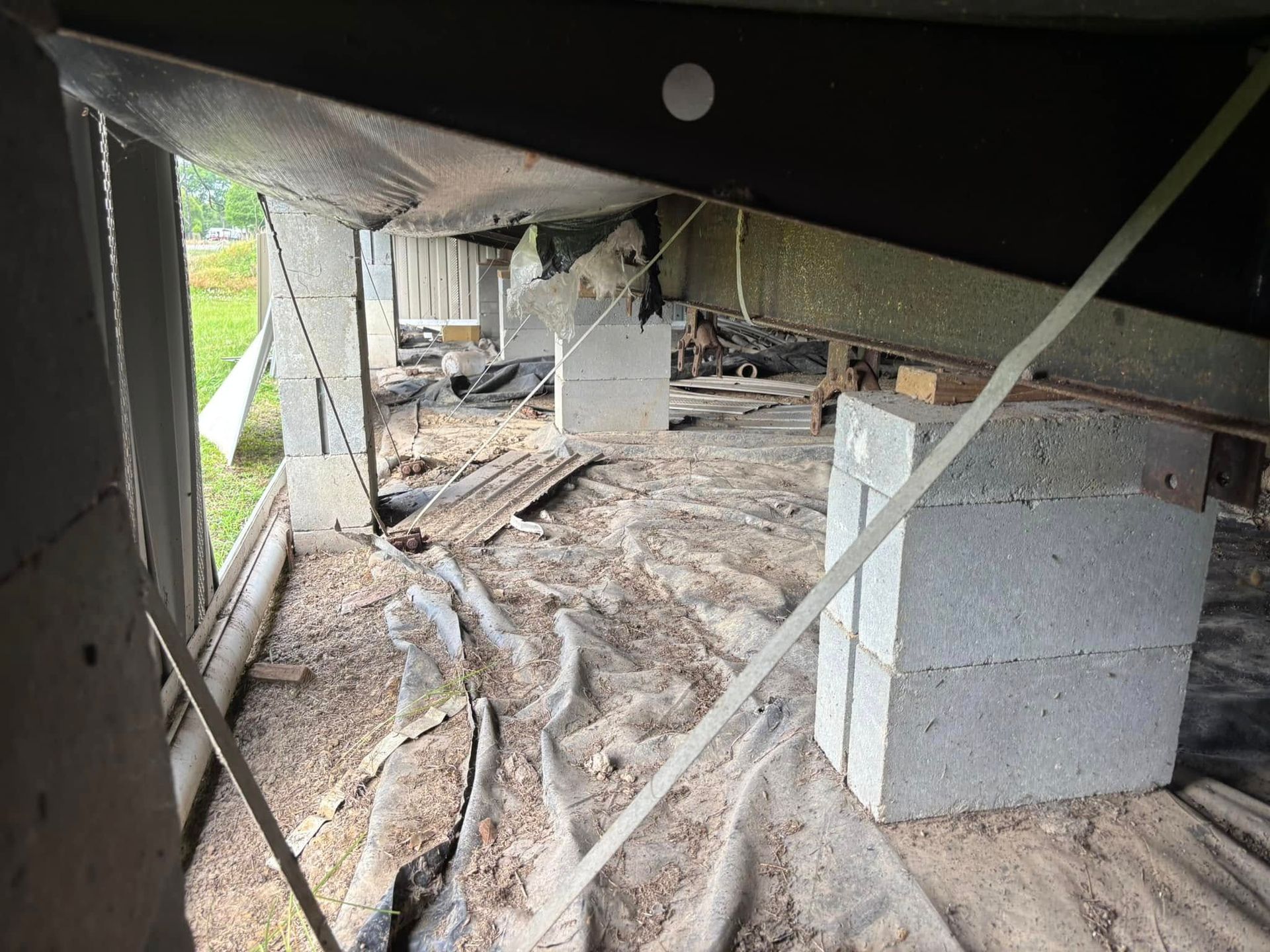 A concrete block is sitting on the ground underneath a building.