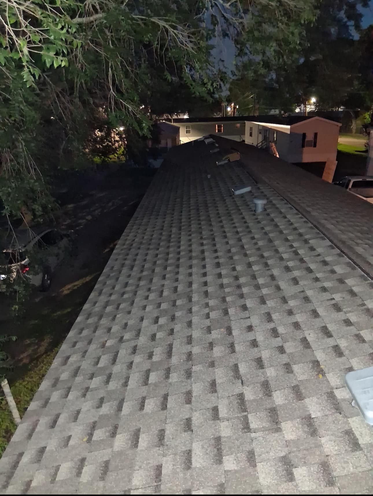 A roof of a house with a lot of shingles on it at night.