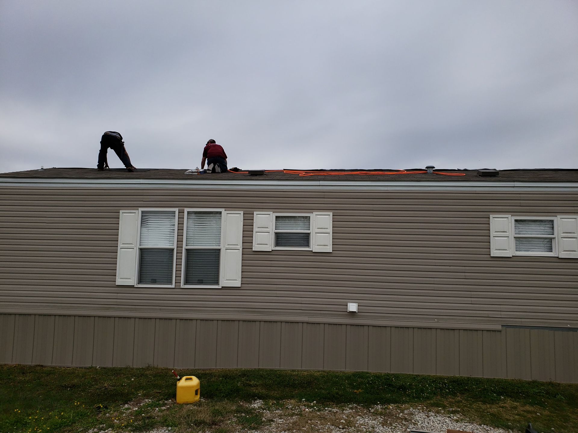 A man is working on the roof of a mobile home
