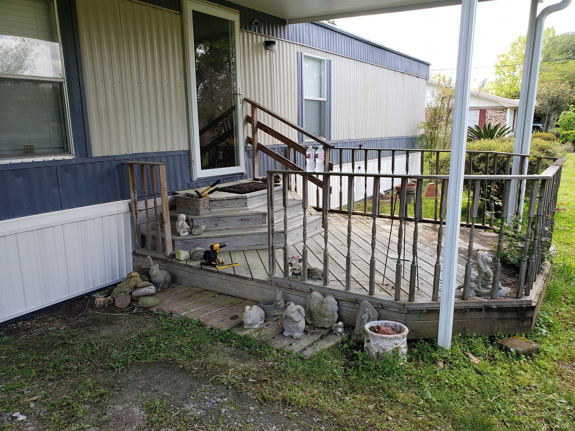 A mobile home with a porch and stairs in front of it.