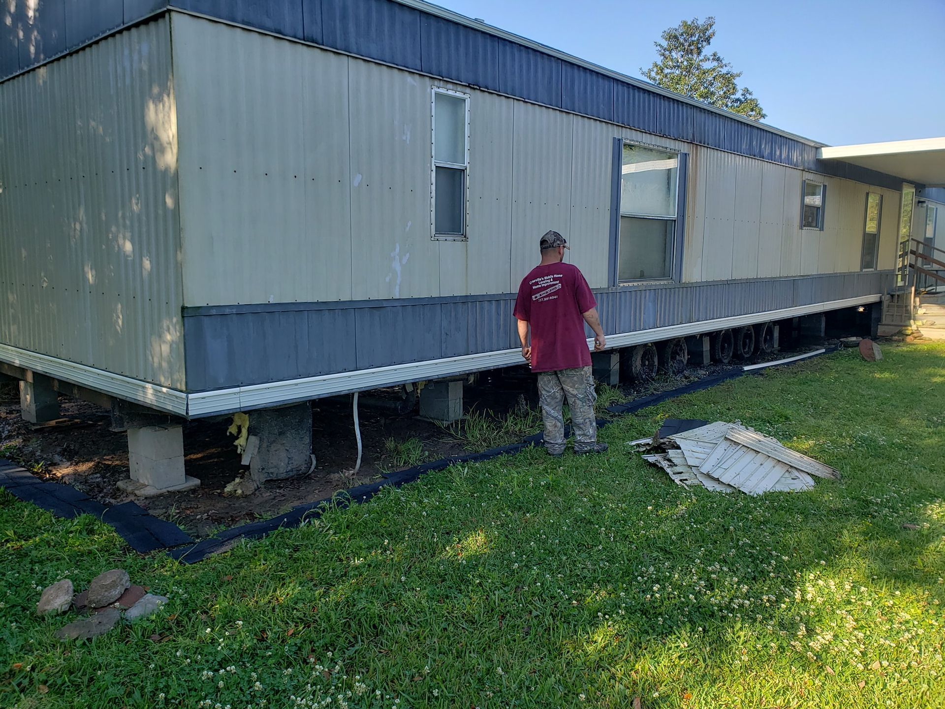 A man is standing in front of a mobile home.