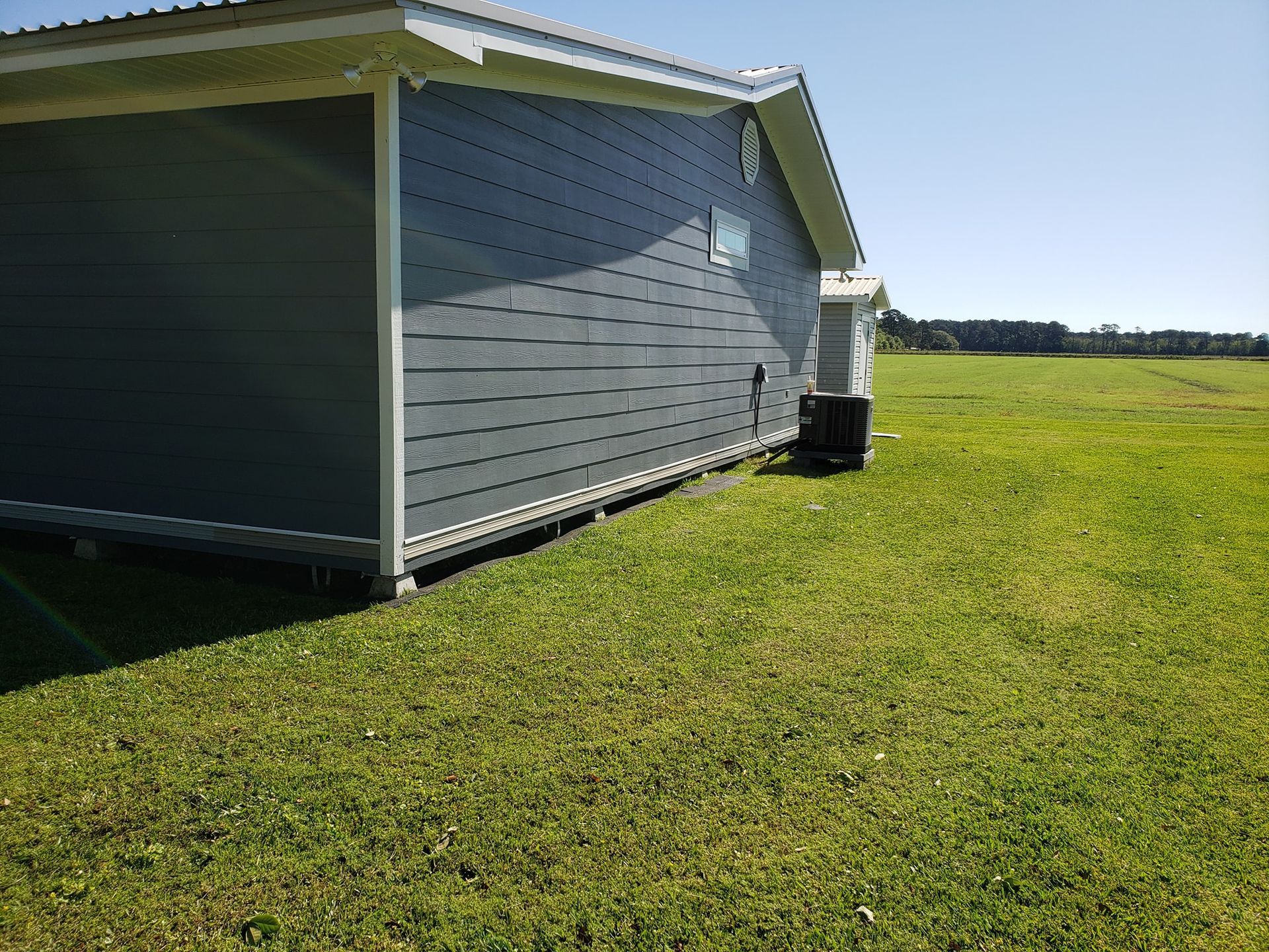 A house is sitting in the middle of a grassy field.