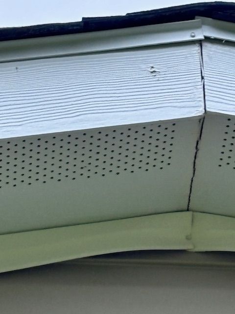 White soffit with ventilation holes at a building corner.