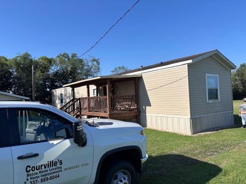 An empty bedroom with a ceiling fan and a window.