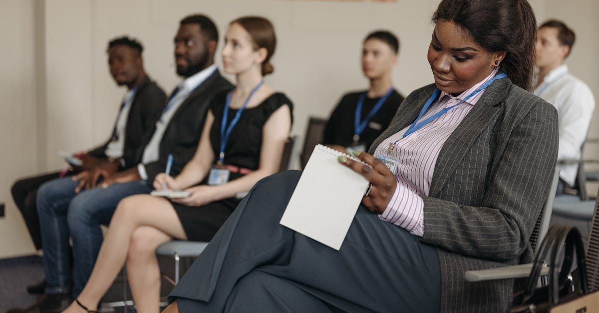 A group of people are sitting in chairs waiting for a job interview.