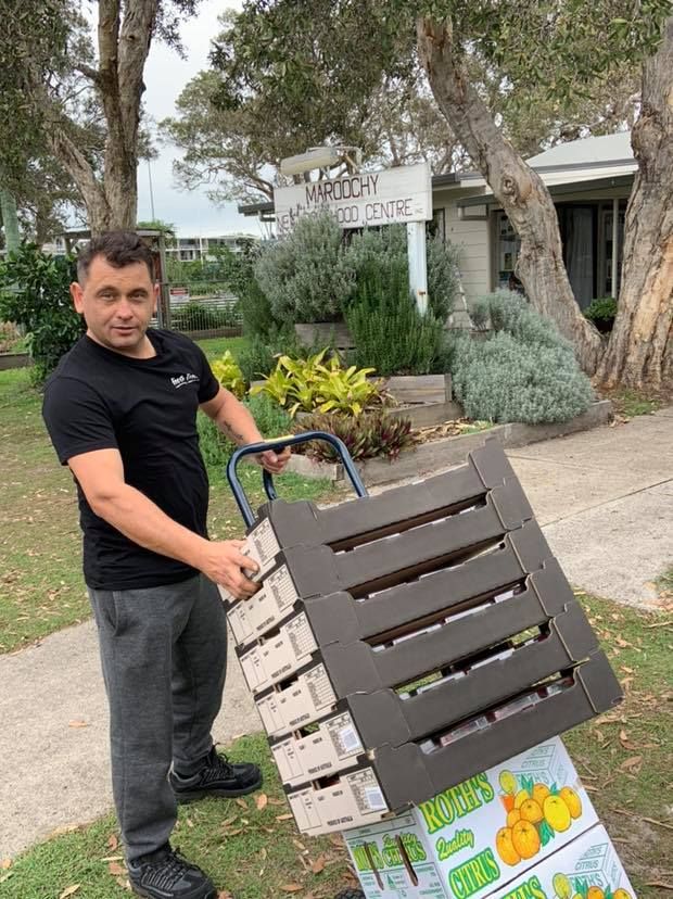 A Man is Pushing a Cart Full of Boxes on a Sidewalk — Fruits & Vegetables in Maroochydore, QLD