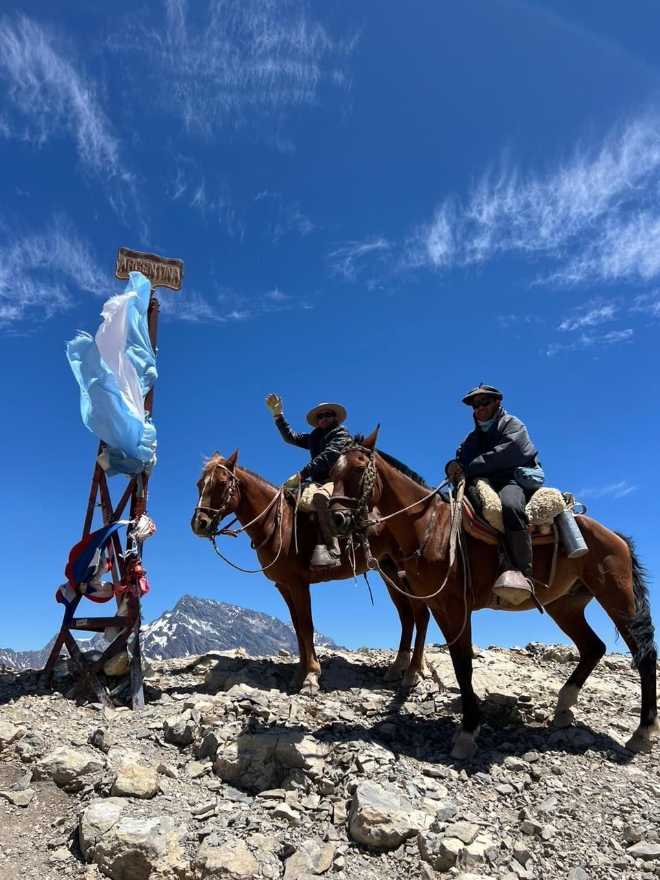 Dos personas a caballo en la cima de una montaña