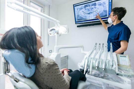 Dentista che mostra una radiografia a una paziente