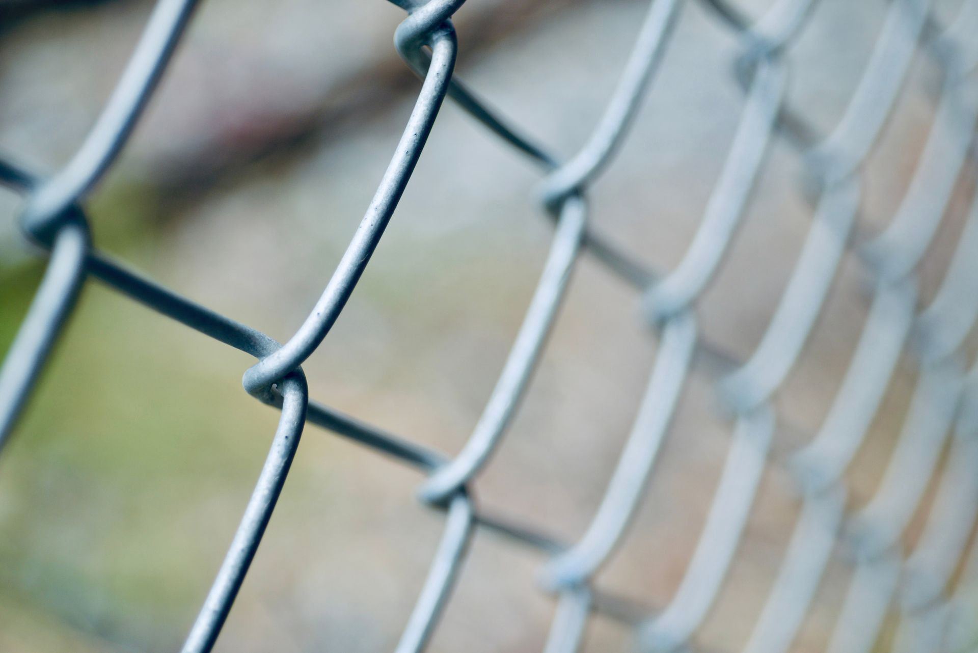 A close up of a chain link fence with a blurry background.