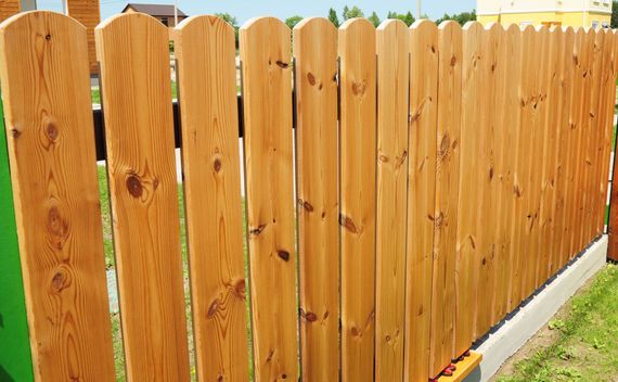 A wooden fence is sitting on top of a concrete base.