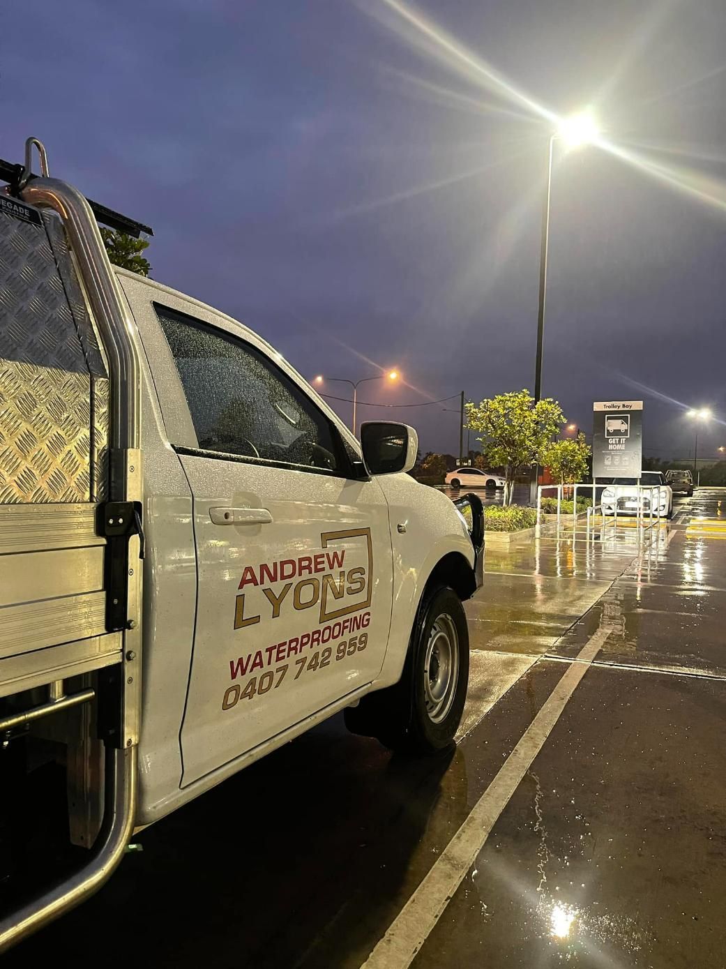 A White Truck is Parked in a Parking Lot at Night — Waterproofing Solutions in Toowoomba, QLD