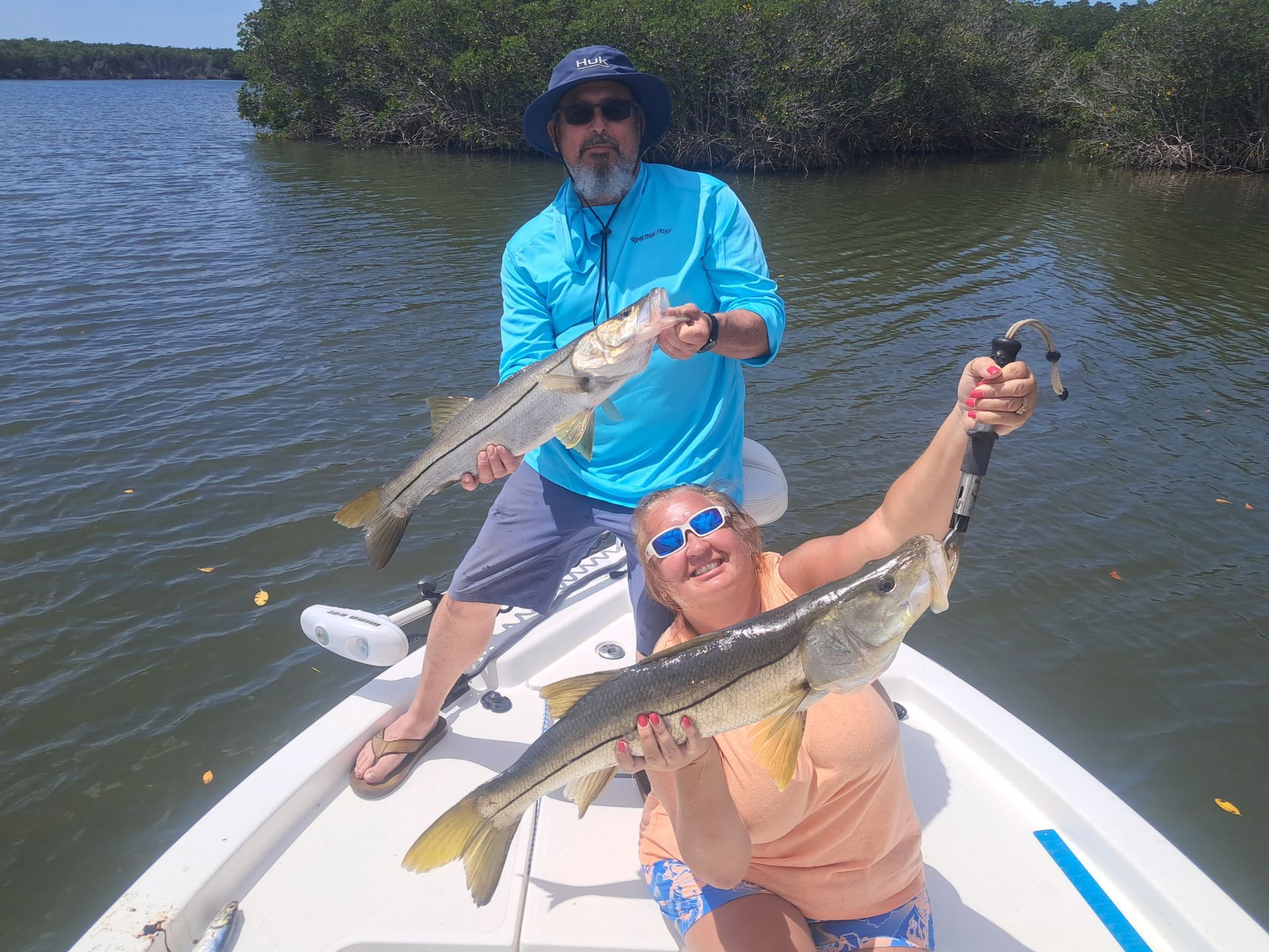 A man is holding a large fish in his hands.