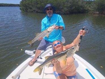 A man is holding a large fish in his hands.