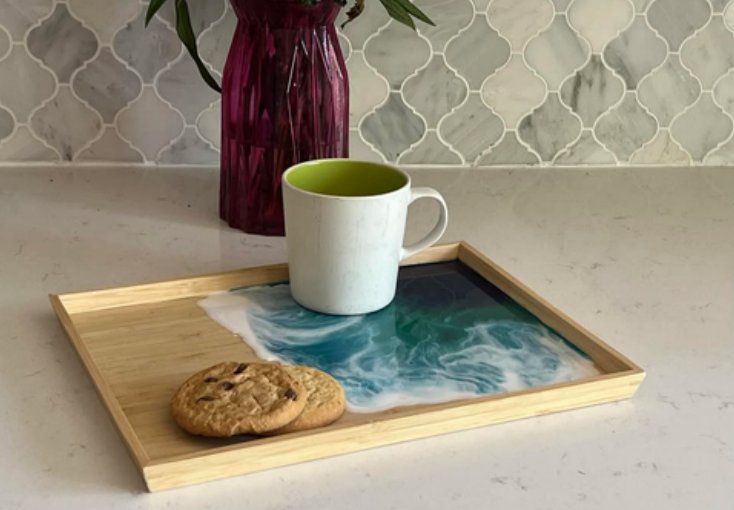 A wooden tray with a cup of coffee and a cookie on it.