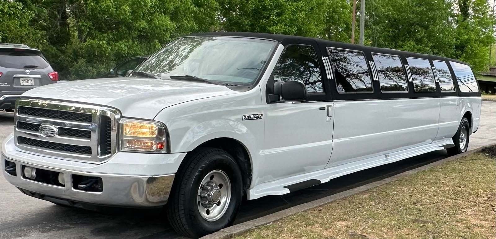A white limousine is parked in a parking lot.