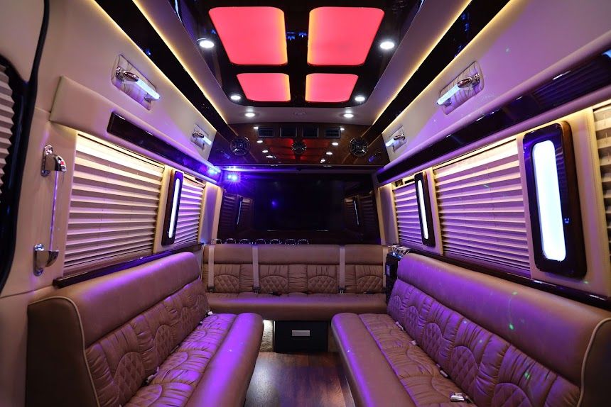 Luxury van interior with purple LED ceiling lights and tan leather bench seating