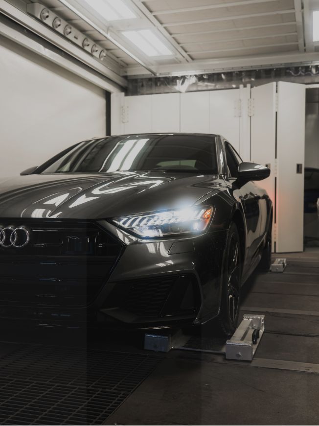 Une voiture Audi noire est garée dans un garage
