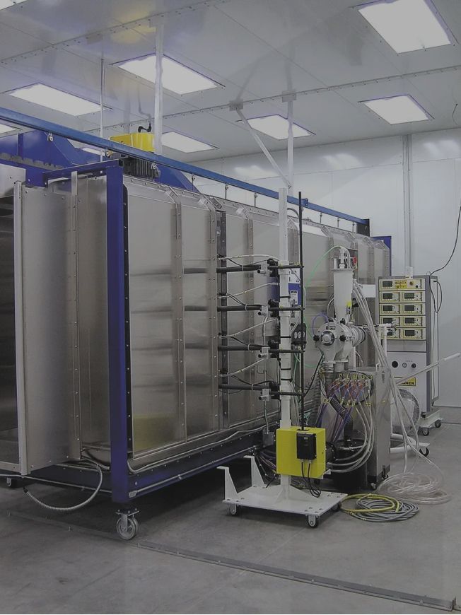A large machine is sitting in a room with a lot of lights on the ceiling.