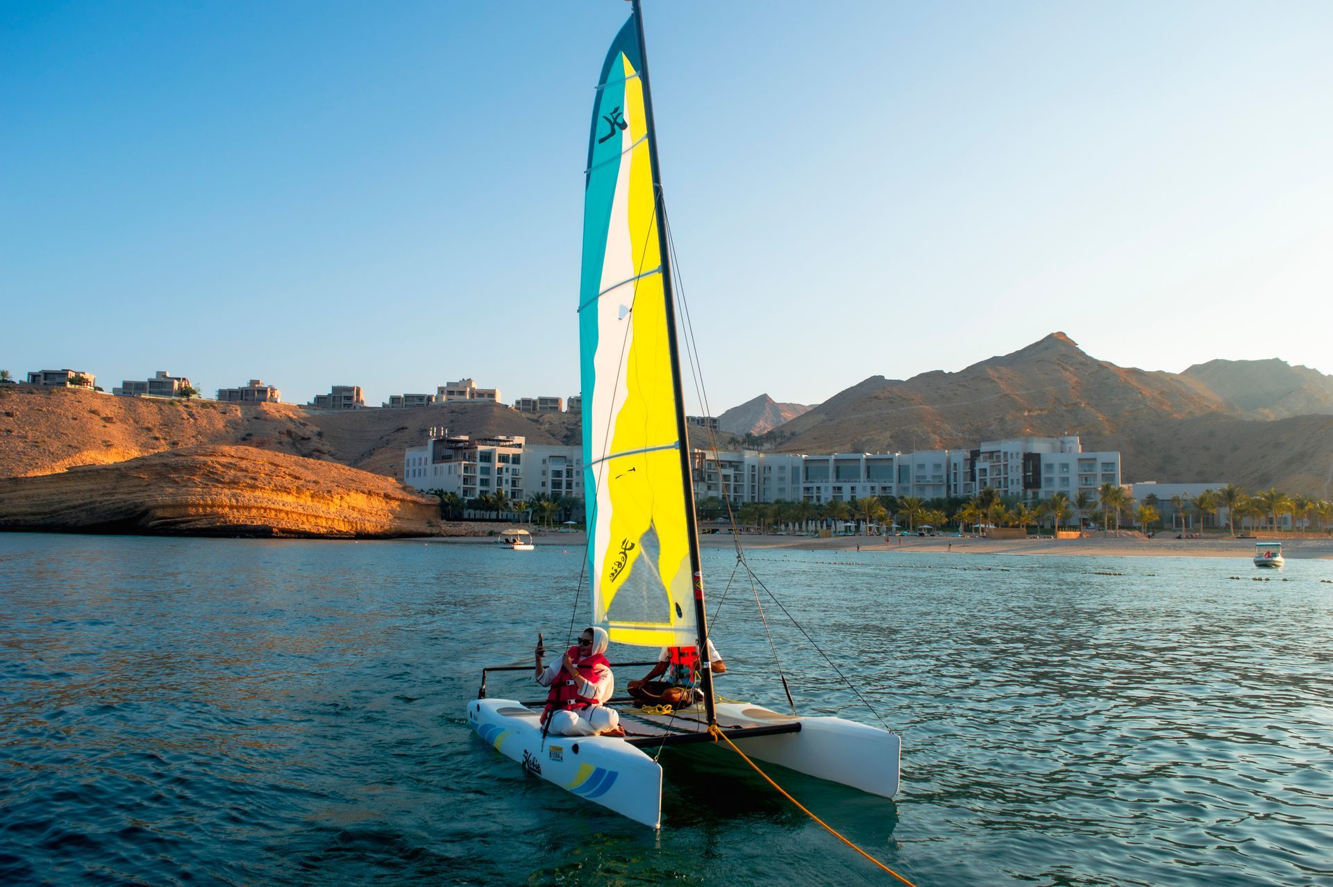 A sailing boat with yellow sail in Oman Sea