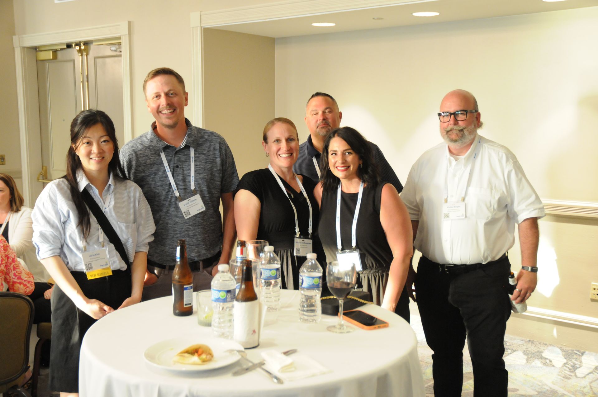 Group of people around a table with drinks and food at an event.