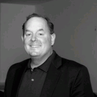 Smiling man in a blazer and polo shirt. Black and white portrait.