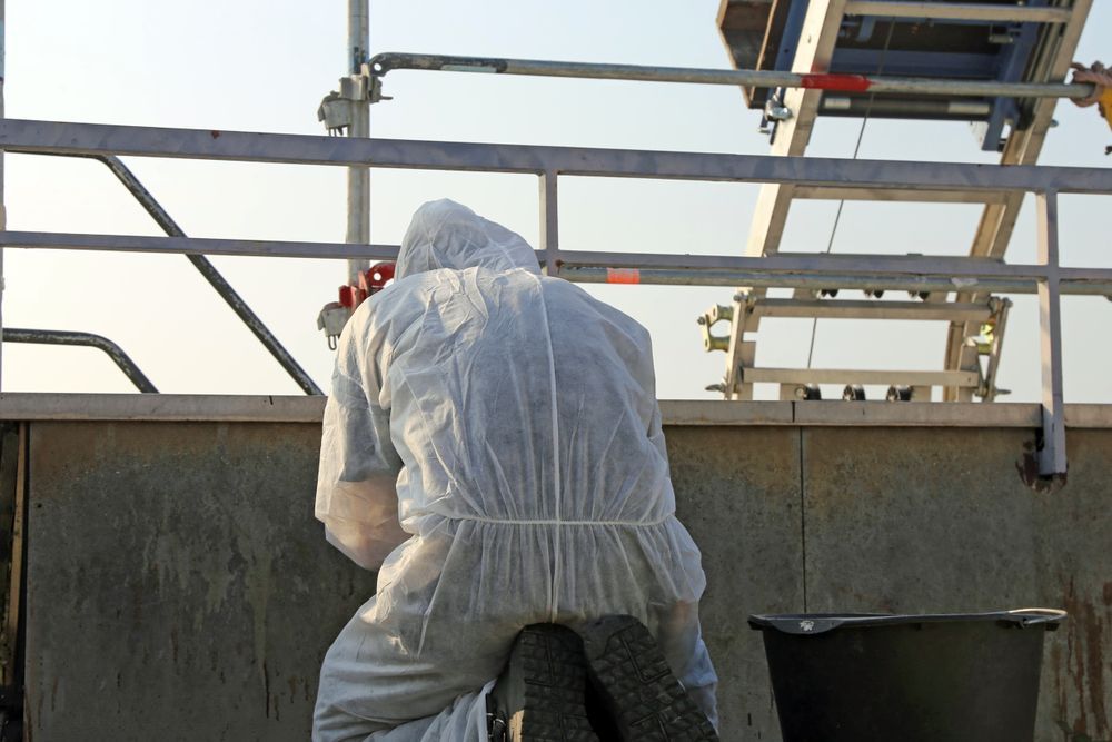 A Man in a Protective Suit is Working on a Boat — On Demand Diggers & Demolitions in Molendinar, QLD