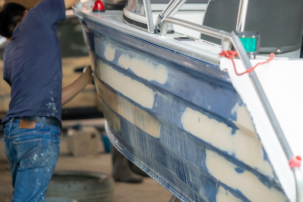 A Man is Working on a Boat in a Garage — On Demand Diggers & Demolitions in Gold Coast, QLD