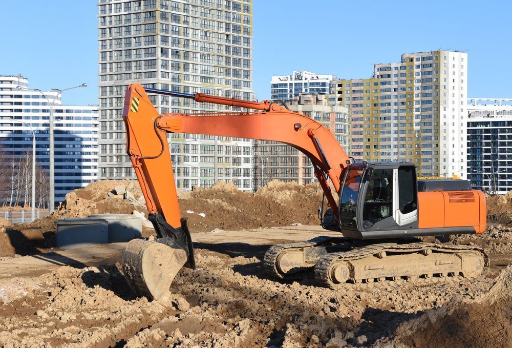 Large Orange Excavator is Digging a Hole in a Construction Site — On Demand Diggers & Demolitions in Gold Coast, QLD