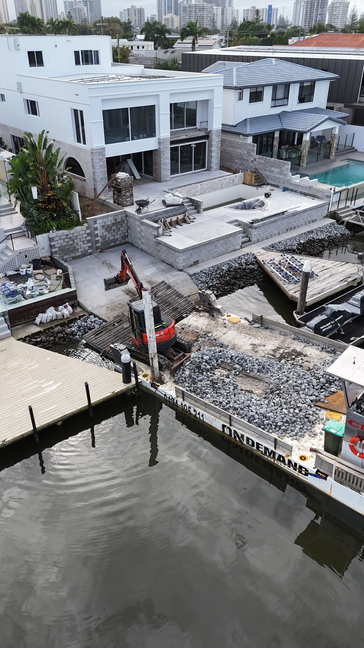 Construction Site Next to a Canal With Excavator — On Demand Diggers and Demolitions in Molendinar, QLD