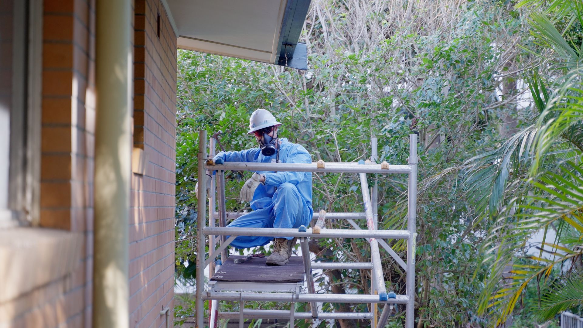 Two Men in Protective Suits Are Removing Asbestos From the Roof  — On Demand Diggers & Demolitions in Molendinar, QLD