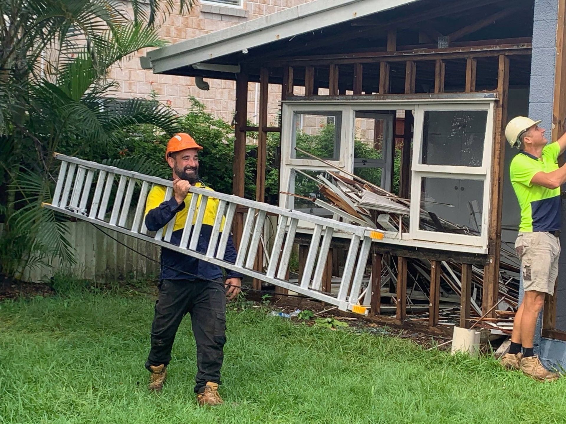 Two Construction Workers Dismantling a Shed