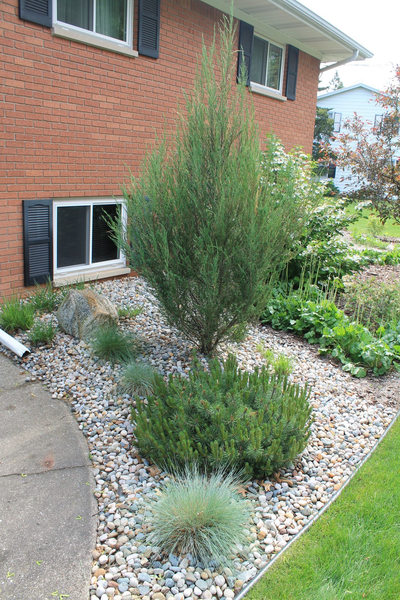 A brick house with a garden in front of it.