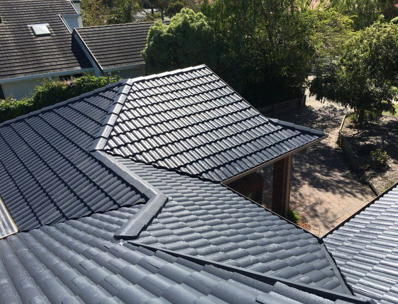 Gray tile roof with angled sections, visible from above, in a residential setting.