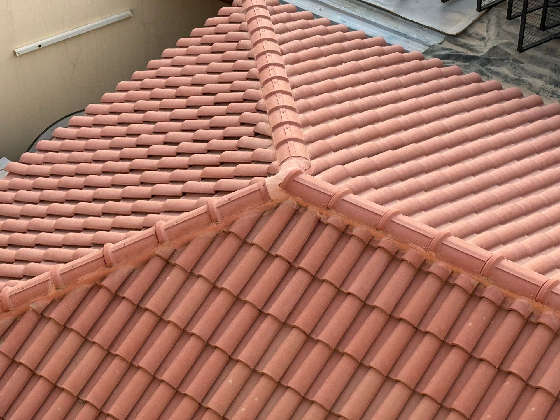 Red clay tile roof with ridge caps and intersecting sections.