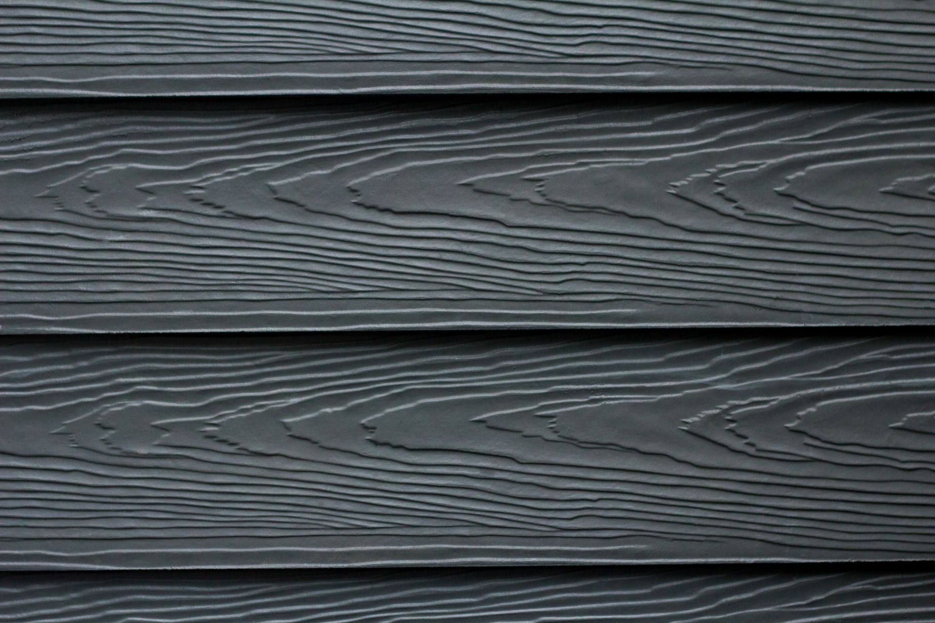 Dark gray wood-look siding with horizontal grooves and textured grain.