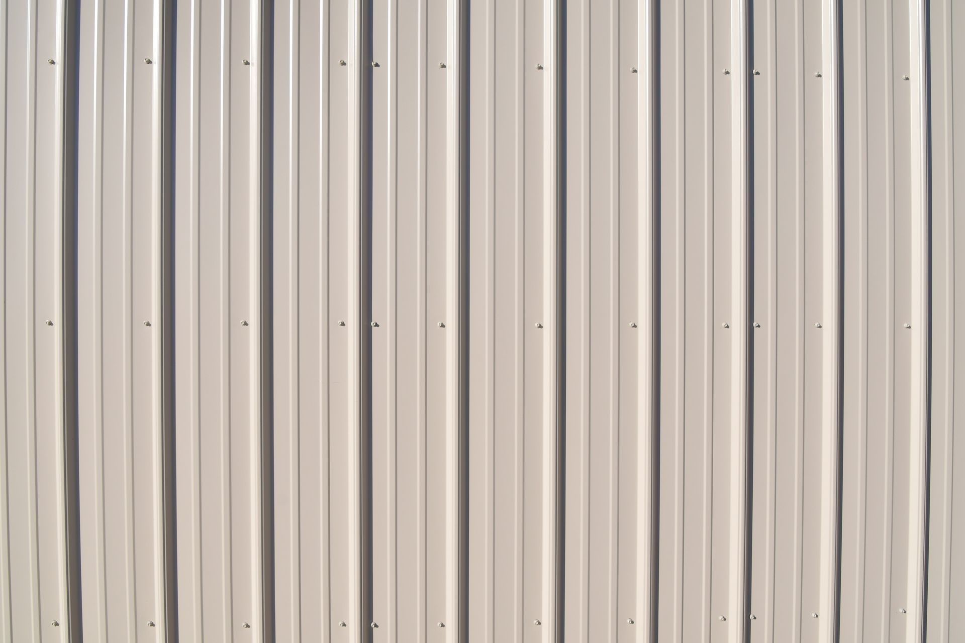 Vertical, corrugated metal siding in a neutral color with visible fasteners.