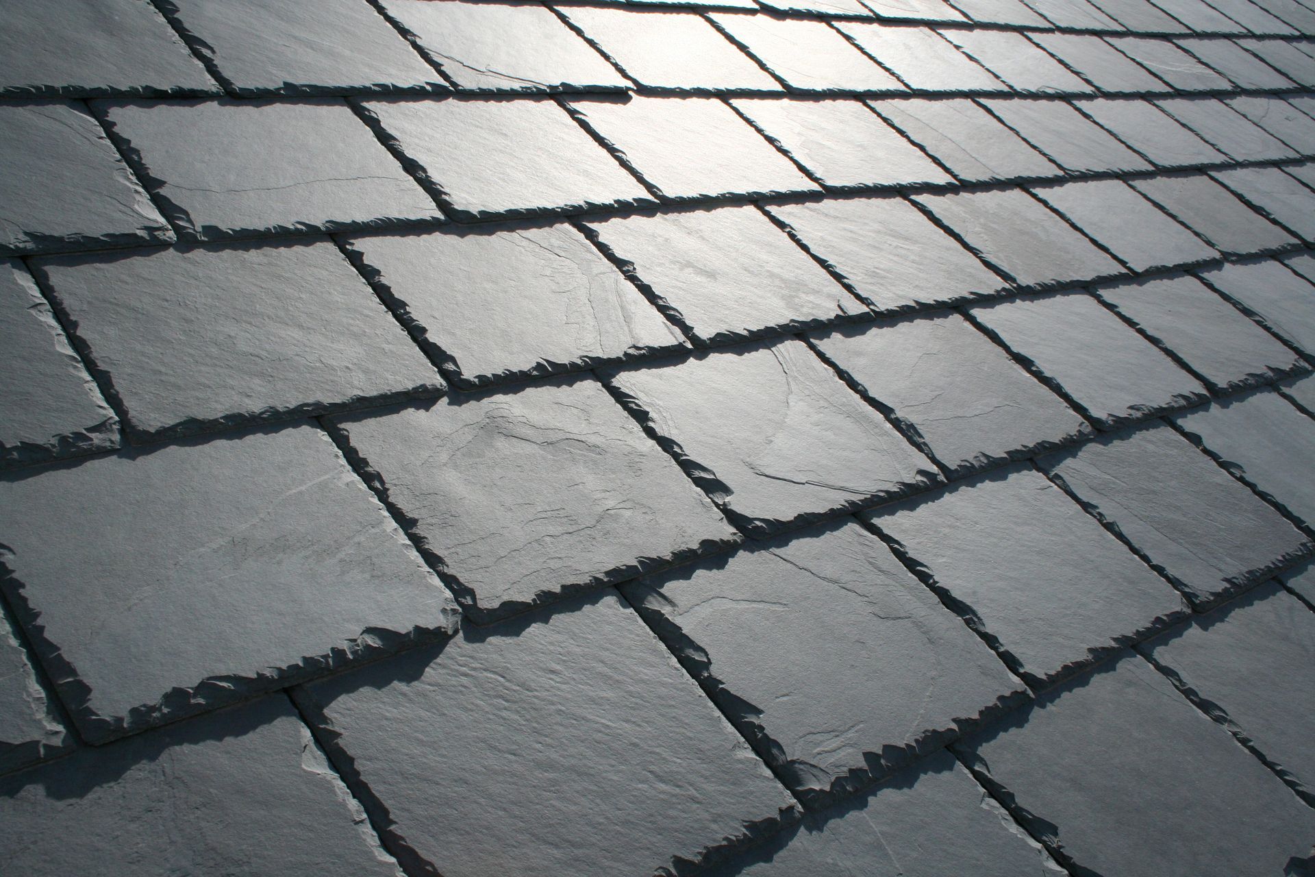Slate roof tiles, dark gray, overlapping pattern.