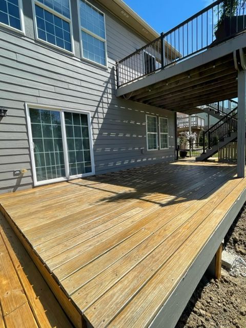 a large wooden deck is sitting in front of a house .