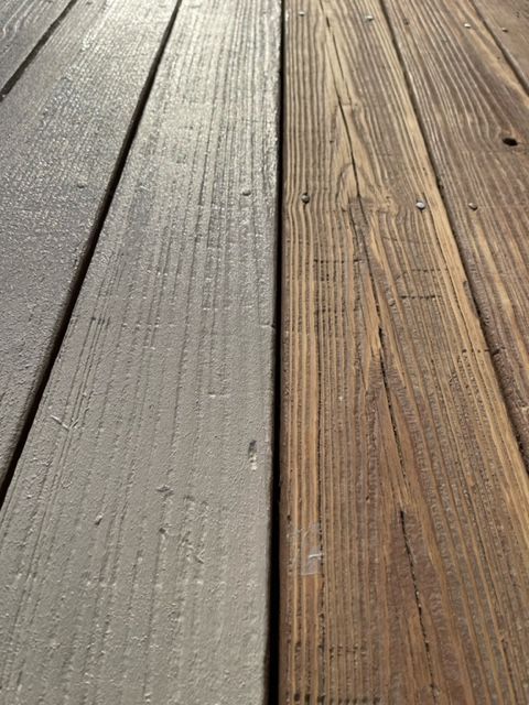 a close up of a wooden deck with a gray stain on it .