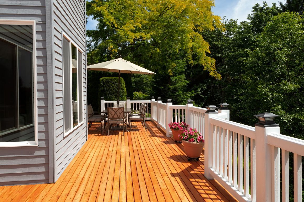 a wooden deck with a white railing and umbrellas